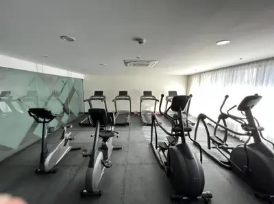 a gym with several rows of exercise bikes in a room at Happy Sunshine Staycation Moa near Airport in Manila