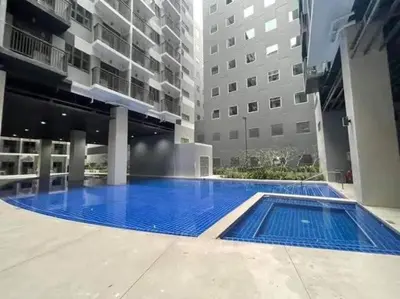 a large swimming pool in the middle of a building at Happy Sunshine Staycation Moa near Airport in Manila
