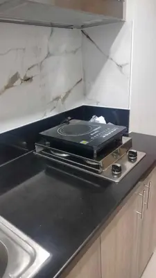a kitchen with a counter top with a stove at Happy Sunshine Staycation Moa near Airport in Manila