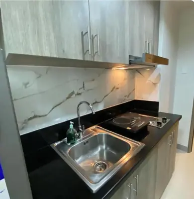 a kitchen with a stainless steel sink and a counter at Happy Sunshine Staycation Moa near Airport in Manila
