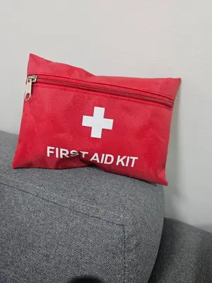 a red first aid kit sitting on top of a couch at Happy Sunshine Staycation Moa near Airport in Manila