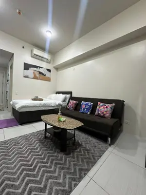 a living room with a couch and a bed at Lugar Kalinaw in Manila