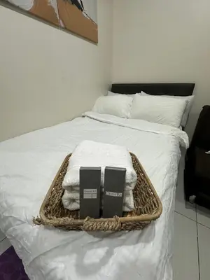 a basket with towels and books on a bed at Lugar Kalinaw in Manila