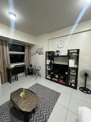 a living room with a coffee table and a flat screen tv at Lugar Kalinaw in Manila