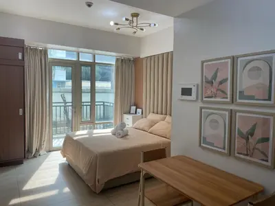 a bedroom with a bed and a view of a balcony at Newport City Rentals in Manila