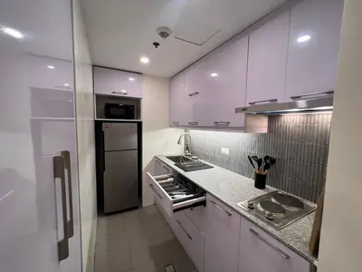 a kitchen with white cabinets and stainless steel appliances at Newport City Rentals in Manila