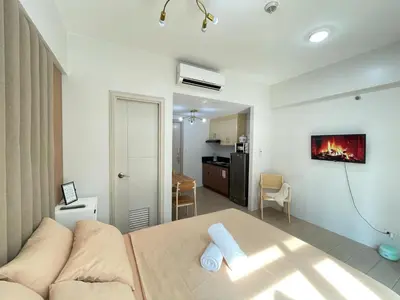 a living room with a couch and a kitchen at Newport City Rentals in Manila