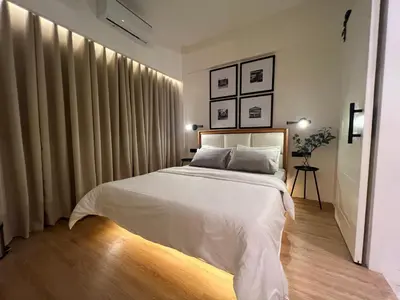 a bedroom with a large bed with white sheets at Newport City Rentals in Manila