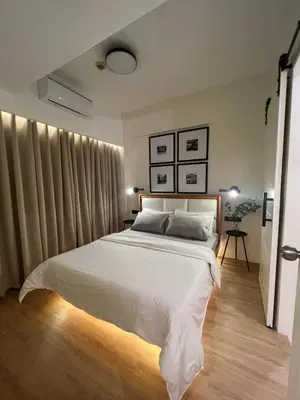 a bedroom with a large bed with white sheets at Newport City Rentals in Manila