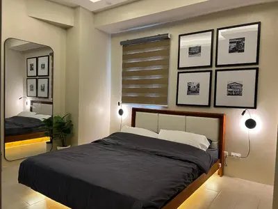 a bedroom with a large bed and a mirror at Newport City Rentals in Manila