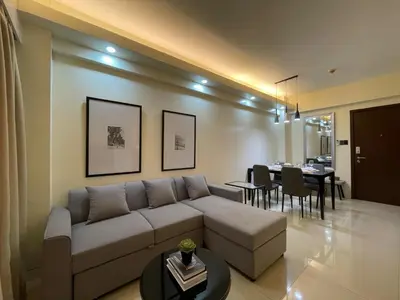 a living room with a couch and a dining room at Newport City Rentals in Manila