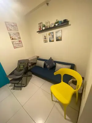 a living room with a blue couch and a yellow chair at The Teal Deal in Manila