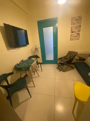 a living room with a tv and a table and chairs at The Teal Deal in Manila