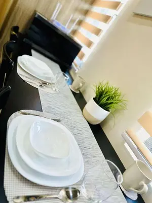 a table with white plates and glasses on it at Royal Fame Residency in Manila