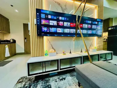 a living room with a large television above a sink at Royal Fame Residency in Manila