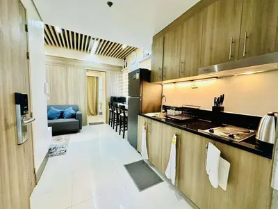 a kitchen with a counter and a couch in a room at Royal Fame Residency in Manila