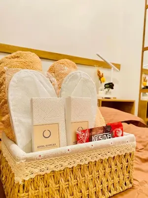 a basket filled with bread and other items on a bed at Staycation by Mailine in Manila