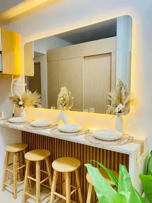 a kitchen with a counter with stools and a mirror at Staycation by Mailine in Manila