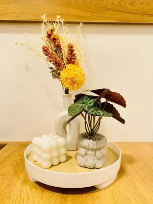 a table with a vase and flowers on a table at Staycation by Mailine in Manila