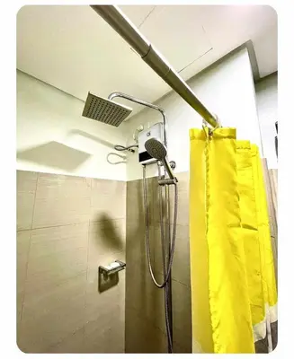 a shower with a yellow shower curtain in a bathroom at SHORE 2n3 RESIDENCES in Manila