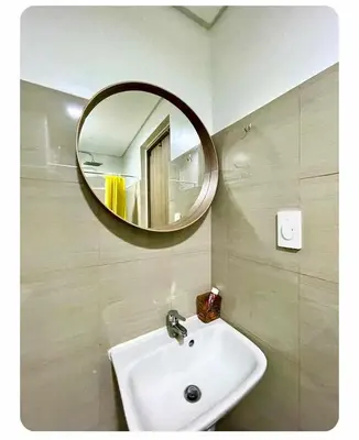 a bathroom with a sink and a mirror on the wall at SHORE 2n3 RESIDENCES in Manila