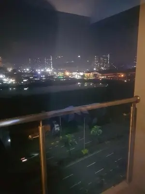 a view of a city at night from a balcony at SHORE 2n3 RESIDENCES in Manila