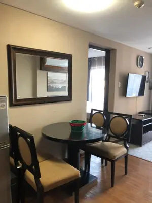 a dining room with a table and chairs and a mirror at A Venue Residences Tower 12L in Manila