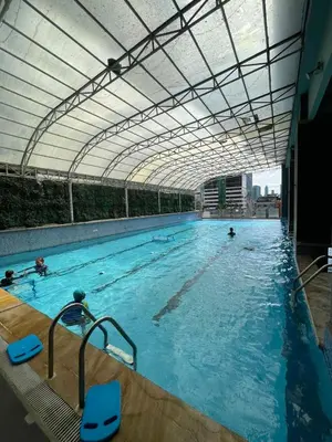 a large swimming pool with people in the water at A Venue Residences Tower 12L in Manila
