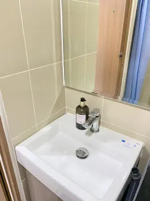 a bathroom sink with a bottle of soap on it at Shore 3 - Unit Chloe - Brand New and Relaxing 1BR in Manila