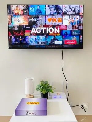 a tv hanging on a wall above a table with a plant at Shore 3 - Unit Diva - Brand New 1 br Unit Near MOA in Manila