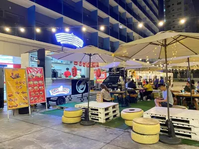 a food stand with tables and umbrellas in a building at Shore 3 - Unit Diva - Brand New 1 br Unit Near MOA in Manila