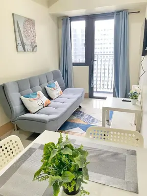 a living room with a couch and a table at Shore 3 - Unit Diva - Brand New 1 br Unit Near MOA in Manila