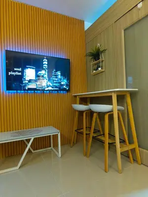 a room with a tv and a table and stools at Mk Luxury Vacation in Manila