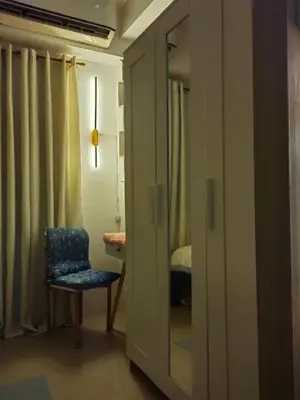 a room with a chair and a door with a bedroom at Mk Luxury Vacation in Manila