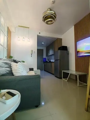 a living room with a couch and a kitchen at Mk Luxury Vacation in Manila