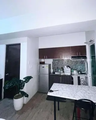 a kitchen with a table and a kitchen with a plant at Anuva Staycation by Gina in Manila