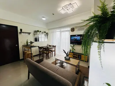 a living room with a couch and a dining room at Casa Tagpuan at Manhattan Heights in Manila