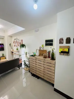 a living room with a couch and a wooden cabinet at Casa Tagpuan at Manhattan Heights in Manila