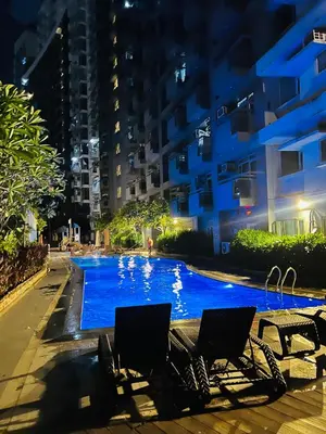 two chairs sitting next to a swimming pool at night at Casa Tagpuan at Manhattan Heights in Manila