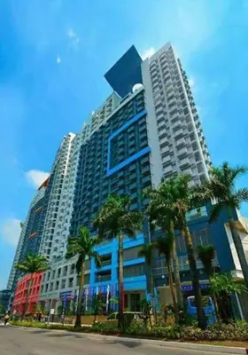 a tall building with palm trees in front of it at Casa Tagpuan at Manhattan Heights in Manila