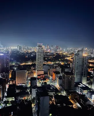 a view of a city at night at New Condo at Grand Riviera Suites across US Embassy in Manila