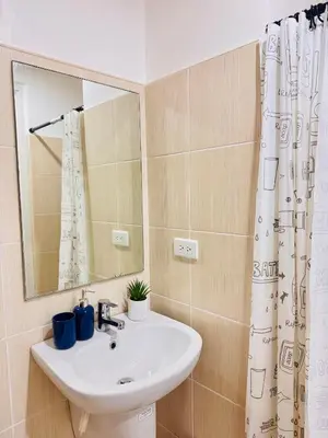 a bathroom with a sink and a mirror at New Condo at Grand Riviera Suites across US Embassy in Manila