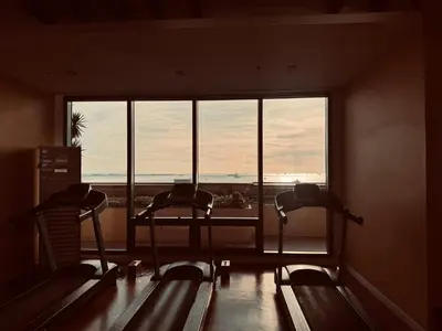two empty chairs in a room with a large window at New Condo at Grand Riviera Suites across US Embassy in Manila