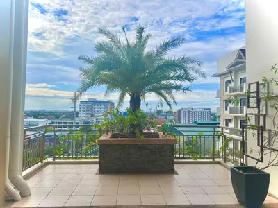a palm tree on the balcony of a building at Calathea Luxe Atrium Suite in Manila