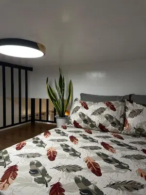 a bed with a floral comforter in a room at Binangonan Jarmelas Tiny Home with Free Breakfast in Binangonan
