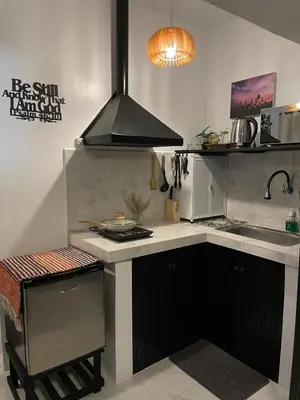a kitchen with a sink and a stove top oven at Binangonan Jarmelas Tiny Home with Free Breakfast in Binangonan