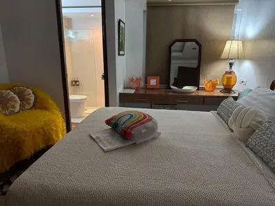 a bedroom with a bed and a bathroom with a mirror at Julie Annes Guesthouse in the Heart of the City in Manila