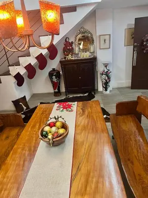 a wooden table with a bowl of fruit on it at Julie Annes Guesthouse in the Heart of the City in Manila