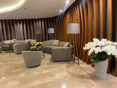 a living room with couches and chairs and flowers at shore 2 residences tower 2 16fl in Manila