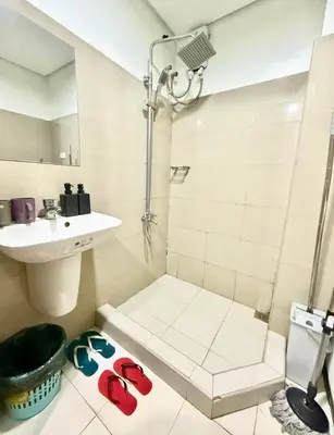 a bathroom with a shower and a sink and slippers at shore 2 residences tower 2 16fl in Manila
